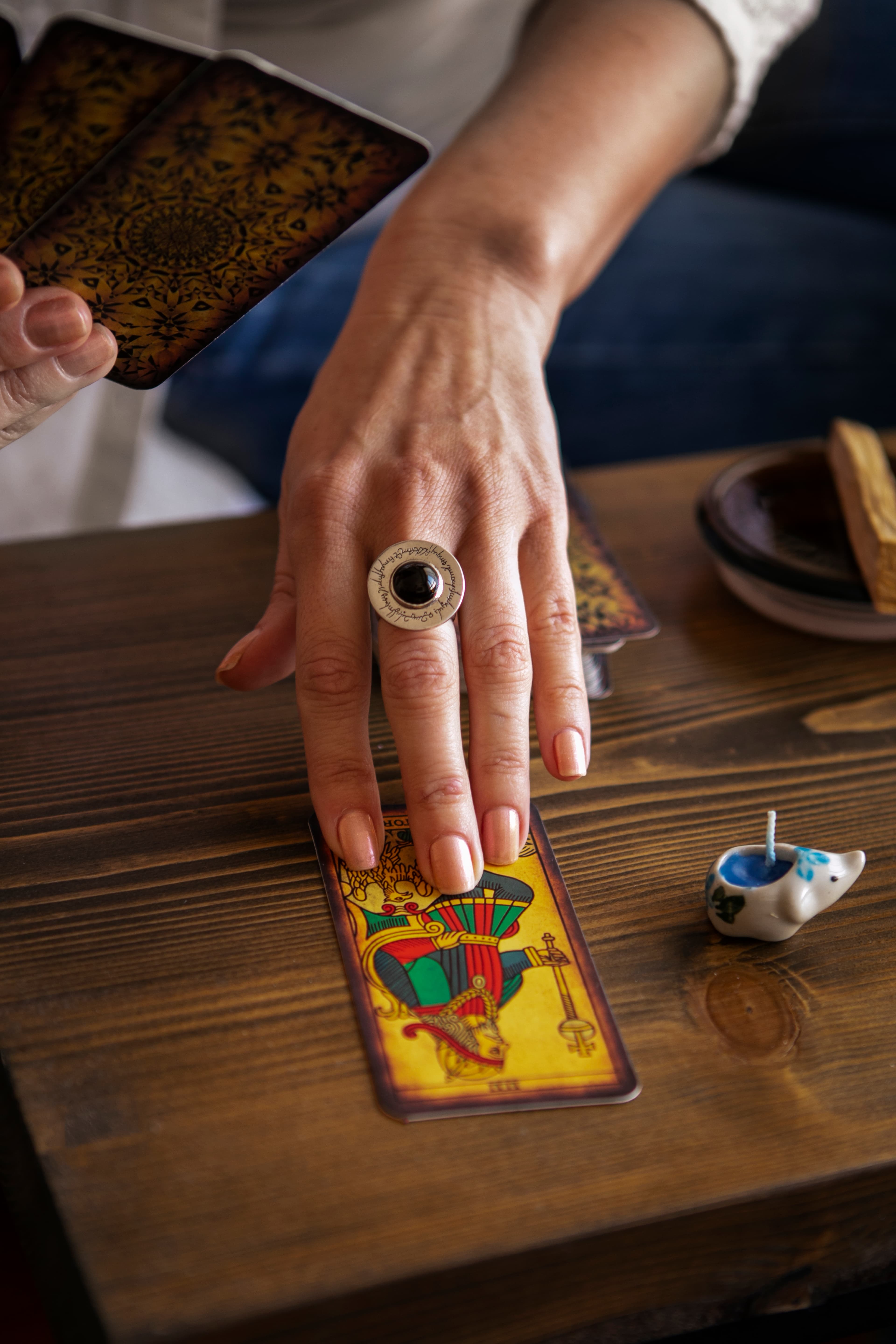 Mano realizando una lectura de tarot sobre una mesa